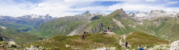 Panoramablick auf die Schweizer Alpen - Kanton Graubünden in der Ostschweiz, ein potenzielles natürliches H2-Explorationsgebiet. Panoramablick auf die Alpen mit vielen wandernden Menschen auf den Wegen