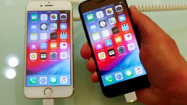 FILE PHOTO: An employee of German Apple retailer Gravis displays an iPhone 7 and 8 in a store in Berlin FILE PHOTO: An employee of German Apple retailer Gravis displays an iPhone 7 and 8 in a store in Berlin