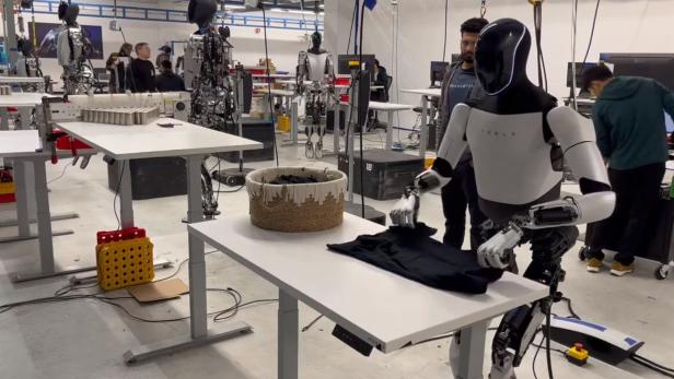 Der Roboter Optimus kann Wäsche (noch) nicht alleine falten. Der Roboter Optimus kann Wäsche (noch) nicht alleine falten.