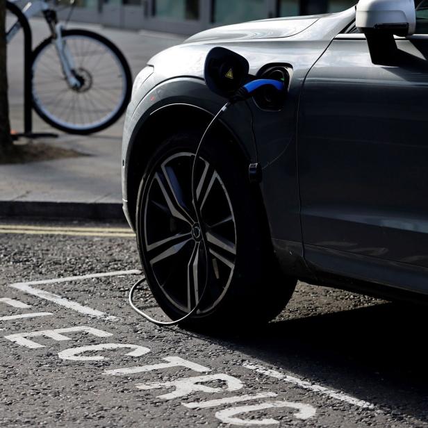 Elektroauto mit Ladekabel an einem Parkplatz mit Electric-Markierung auf dem Asphalt